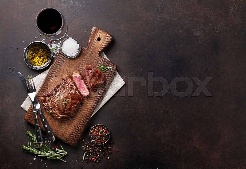 Grilled ribeye beef steak with red wine, herbs and spices. Top view with copy space for your text, stock photo