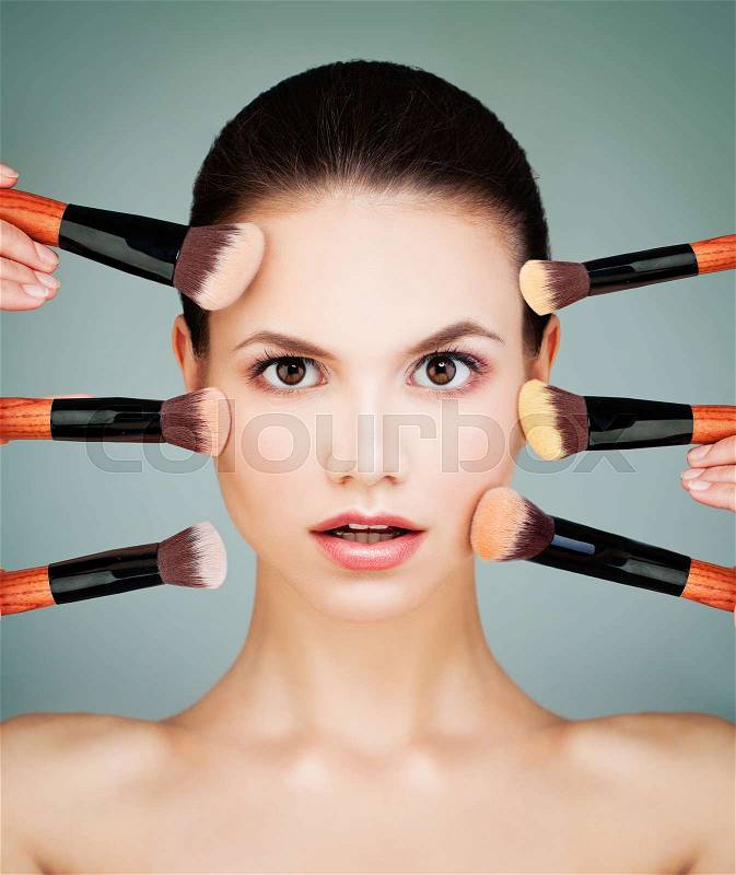 Perfect Woman with Makeup Brush. Nude Makeup, Beautiful Face on Blue Background, stock photo
