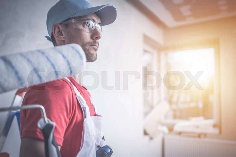 Room Painting Job. Caucasian Room Painter with Painting Roller, stock photo