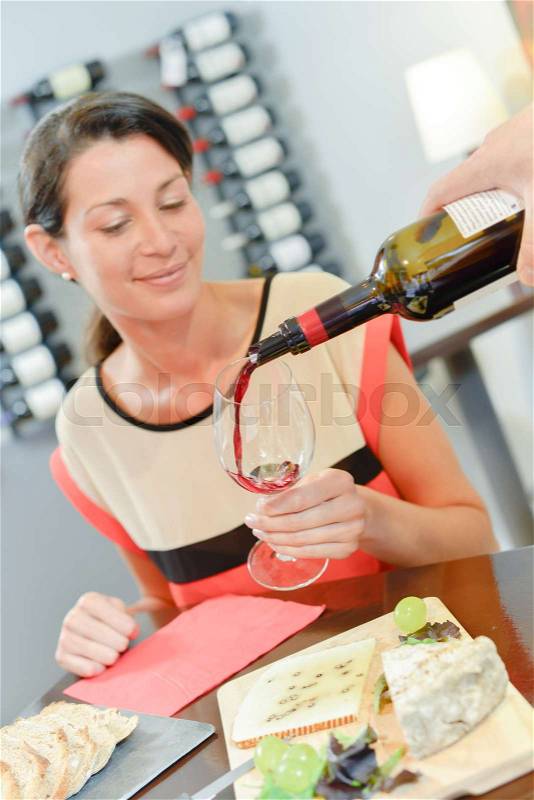 Lady having wine poured for her, stock photo