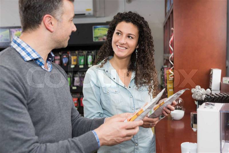 Man and lady looking at coffee pods, stock photo
