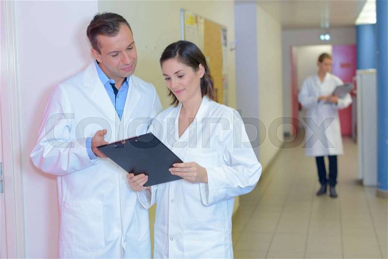 Male and female nursing staff in discussion, stock photo