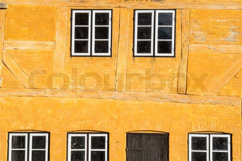 European building styles. detail of yellow timber framed house with white small windows, stock photo
