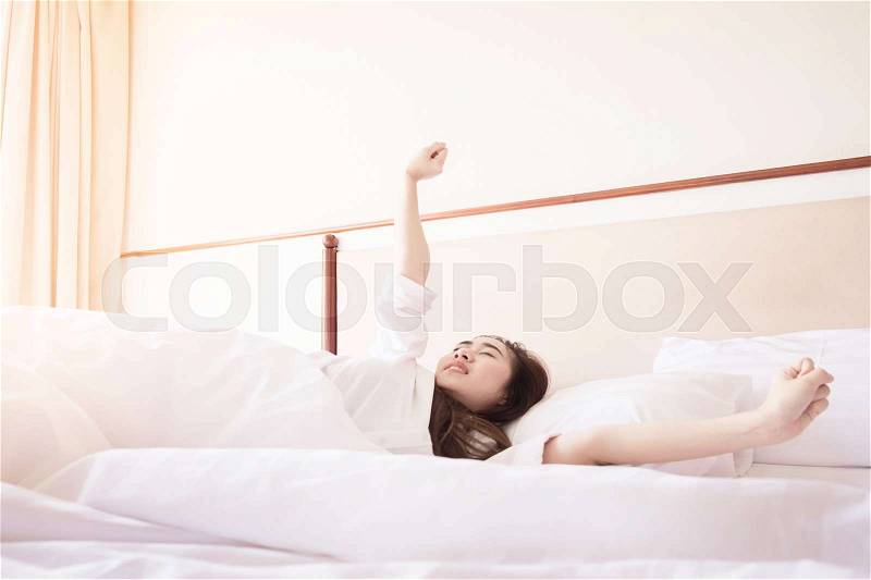 Healthy Woman stretching in bed room and open the curtains after wake up, back view, lifestyle people in cozy indoor comfortable relaxing space, stock photo
