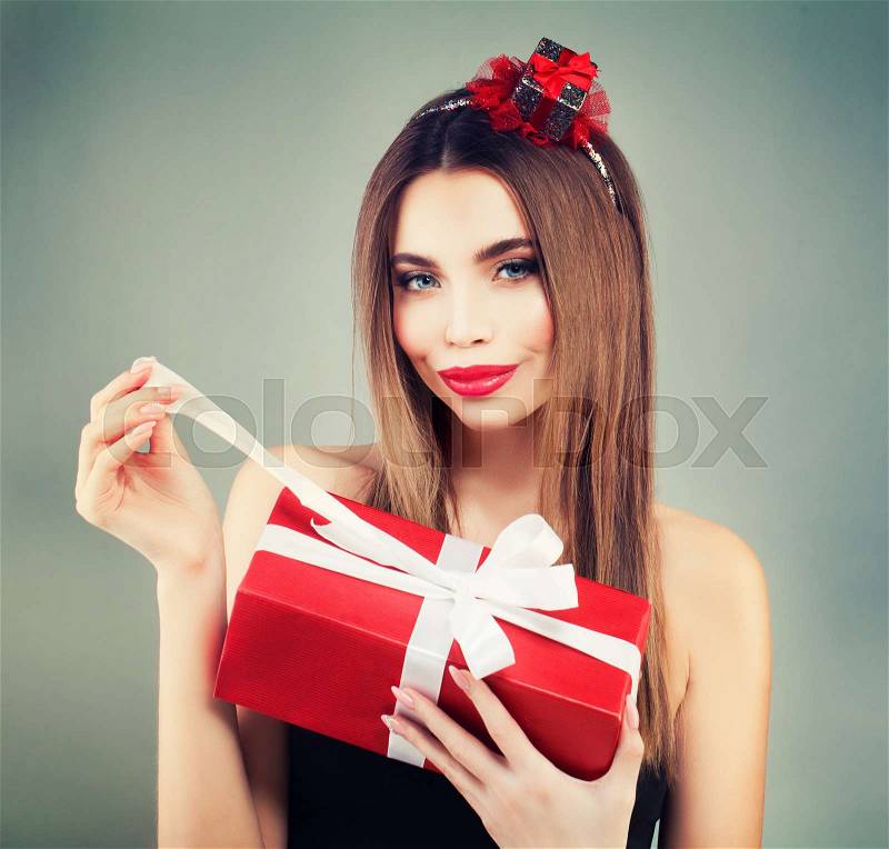 Beautiful Model Woman Open Red Gift Box. Smiling Girl with Perfect Makeup and Hairstyle, stock photo