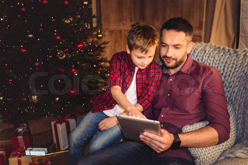 Little son with happy father using digital tablet, stock photo