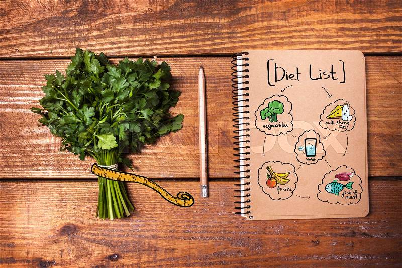 Blank notebook and pencil with a bunch of herbs on wooden board. Diet concept, stock photo