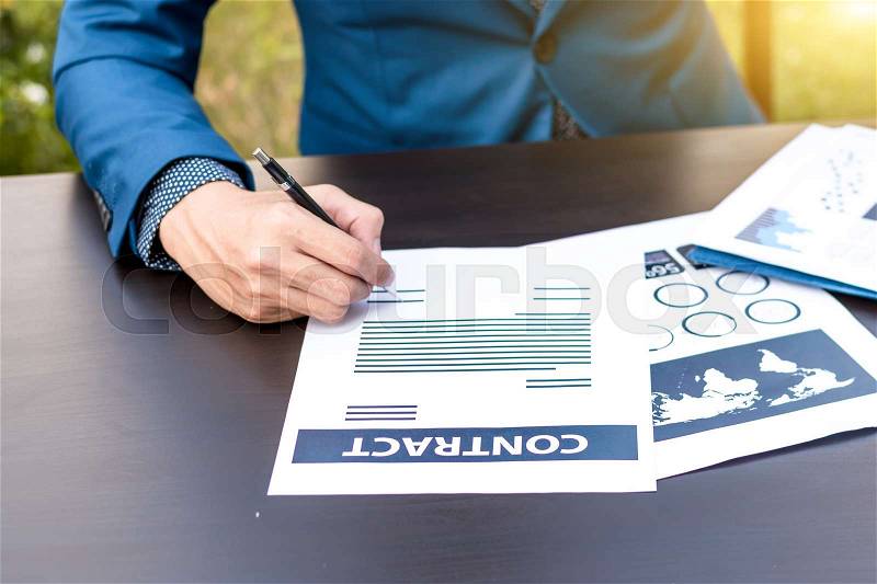 Business insurance lawyer concept : hand using pen sign business contracts agreement paper ,selective focus. , stock photo