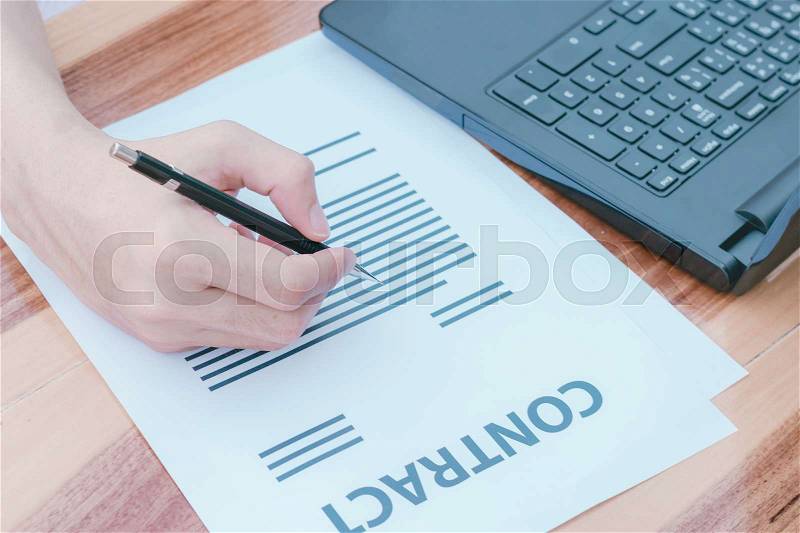Business insurance lawyer concept : hand using pen sign business contracts agreement paper ,selective focus. , stock photo