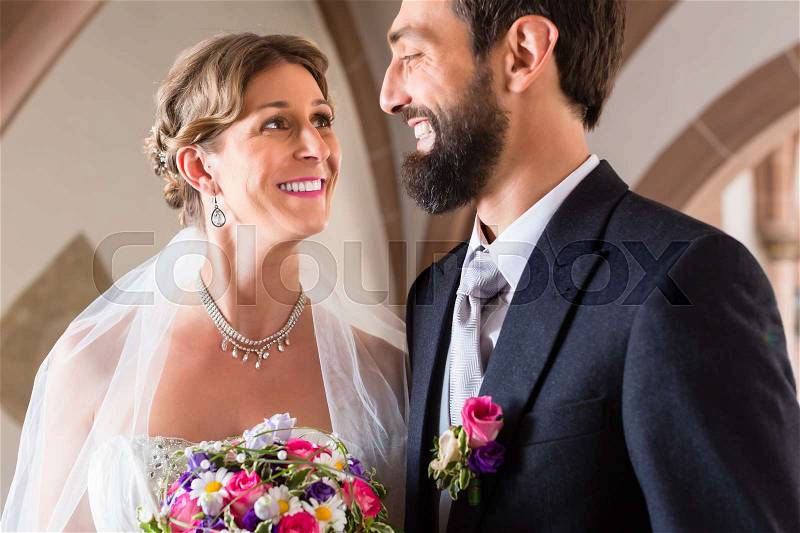 Bride and groom marrying at church wedding, stock photo