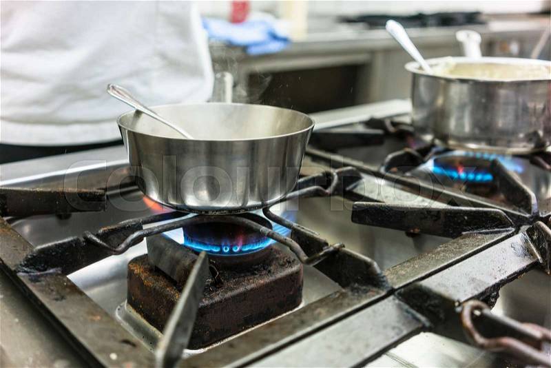 Dish on gas stove in restaurant or hotel kitchen, stock photo