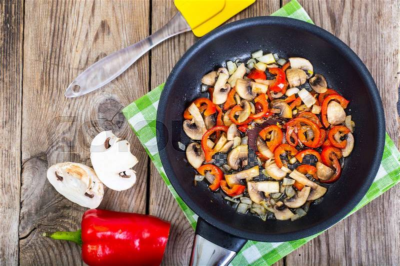 Fried mushrooms with peppers and onions in the pan. View from above. Studio Photo, stock photo