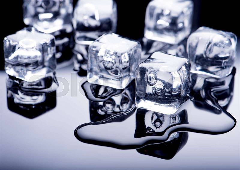 Ice cubes with water on a dark background, stock photo