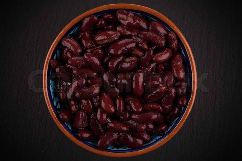 Red kidney beans in a dish in perspective. on dark stone background, stock photo
