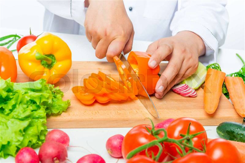 Preparation of cutting vegetables for salad, close up hands of chef with knife, stock photo