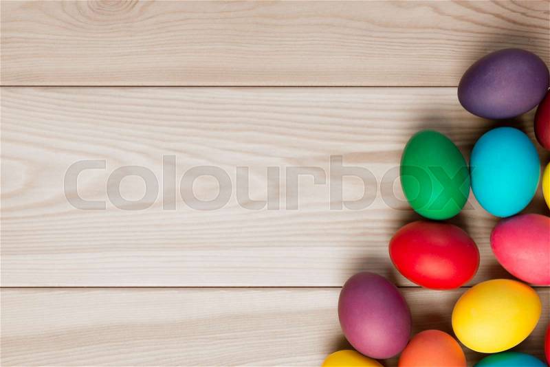 A wooden background for an inscription and a bunch of Easter eggs in the corner, stock photo