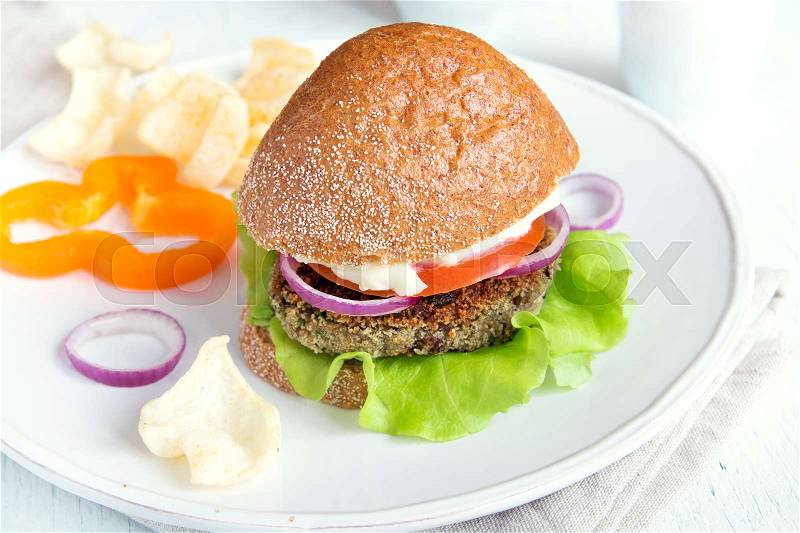 Vegetarian lentil burger with vegetables on white plate - healthy vegan organic vegetarian diet fast food burger lunch, stock photo