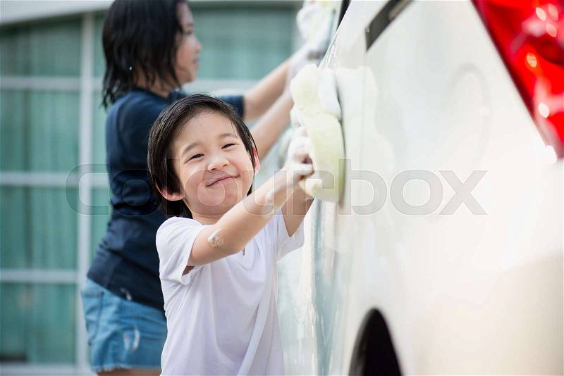 Asian children washing car in the garden on summer day, stock photo