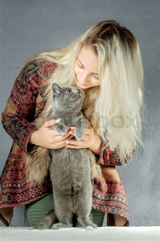 Portrait of a young woman with a cat, stock photo