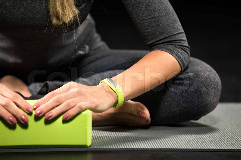 Close-up partial view of sportswoman exercising with yoga block , stock photo