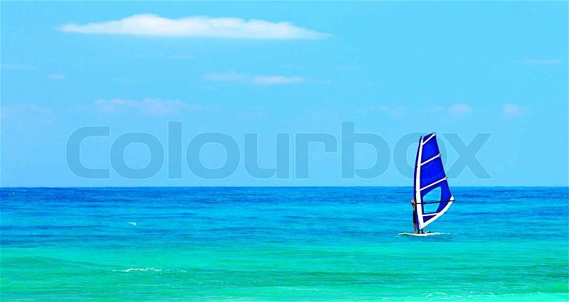 Panoramic beach landscape with windsurfer playing, deep blue sea at summertime, sport active people having fun, stock photo