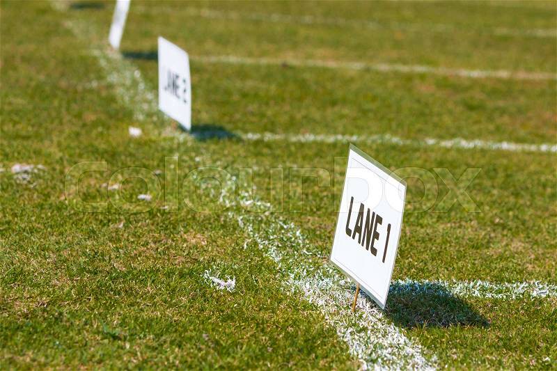 Lane signs on grass field for elementary school track and field tournament, stock photo