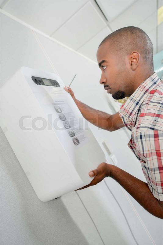 Man fitting electrical box to wall, stock photo