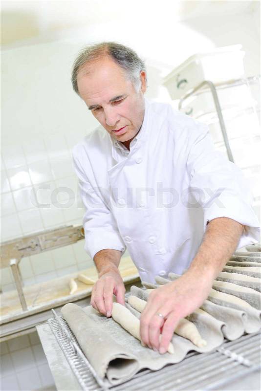 Man preparing baguettes, stock photo
