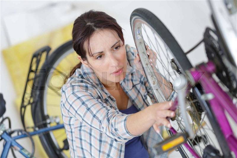 Bicycle mechanic repairing tyre or wheel on bike, stock photo