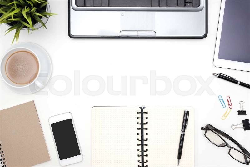 Frame of white office desk table background with computer, supplies, notebook, pen, pencil, tablet, phone, flower, eye glasses and coffee cup, Top view with copy space, stock photo