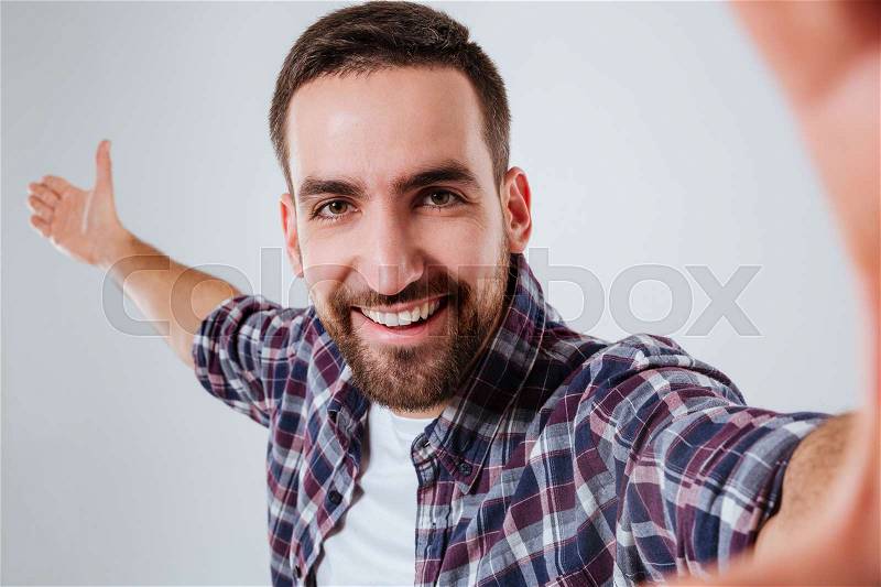 Happy Bearded man in shirt which making selfie. Close up. Isolated gray background, stock photo