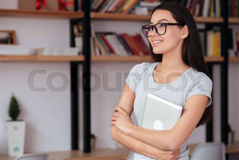 Image of young caucasian amazing woman indoors holding tablet computer. Coworking concept, stock photo