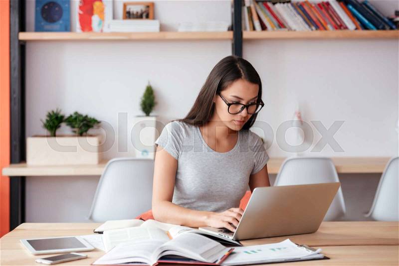 Image of young caucasian amazing woman indoors using laptop computer. Coworking concept, stock photo