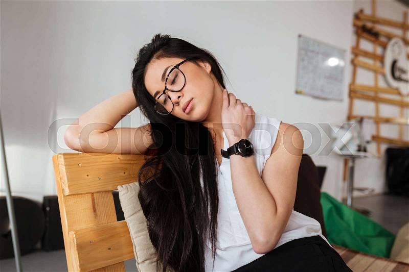 Tired exhausted asian young woman in glasses sitting and relaxing, stock photo