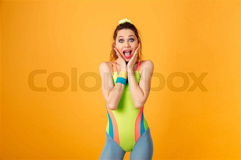 Surprised pretty young fitness woman standing and shouting, stock photo
