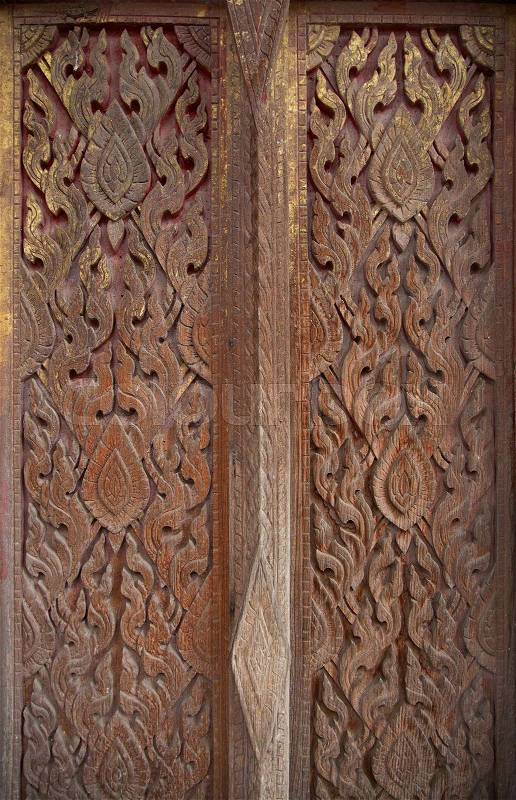 Traditional wood carved door using in a Thai temple, stock photo
