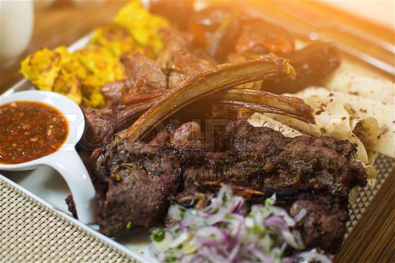 Plate of arabic kebab meat with potato, tomatoes and pita. Traditional eastern kabab dish with marinated onion and spicy sauce. Turkish national cuisine. Lula-kebab, antricot , grilled lamb and beef, stock photo