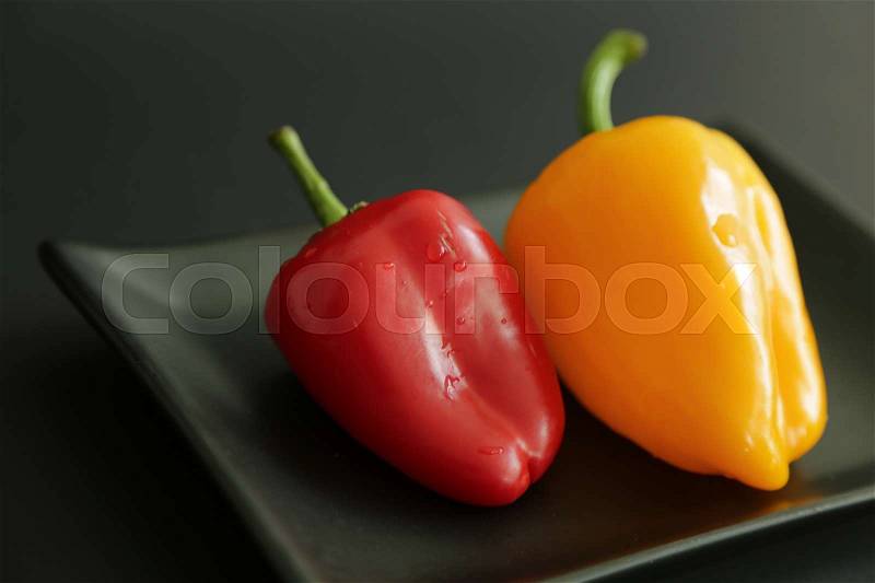 Two sweet peppers black background, stock photo