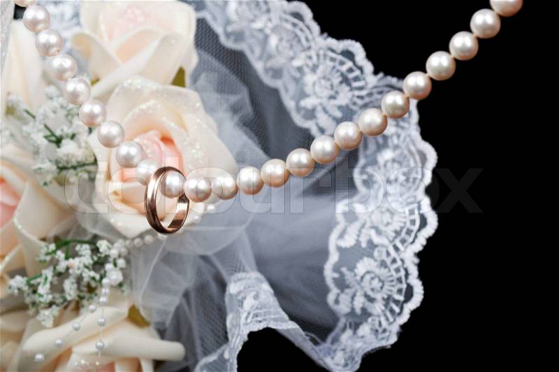 Gold wedding ring on a pearl necklace, stock photo