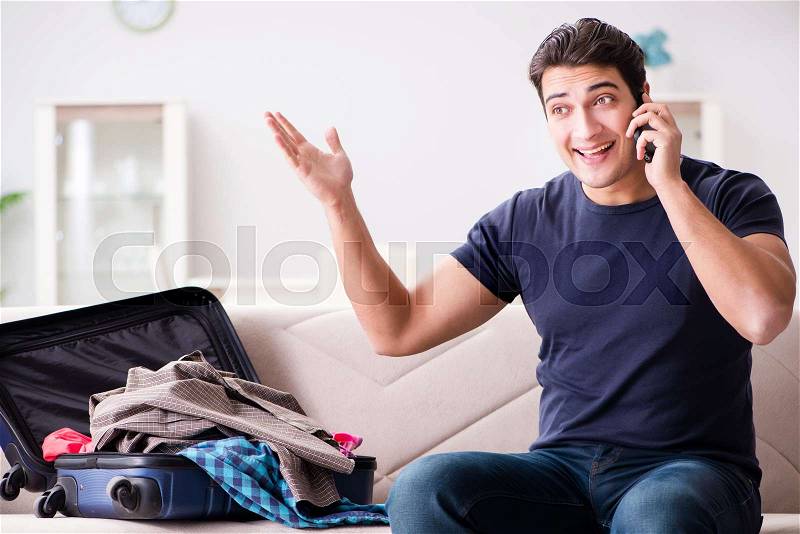 Man going on vacation packing his suitcase, stock photo