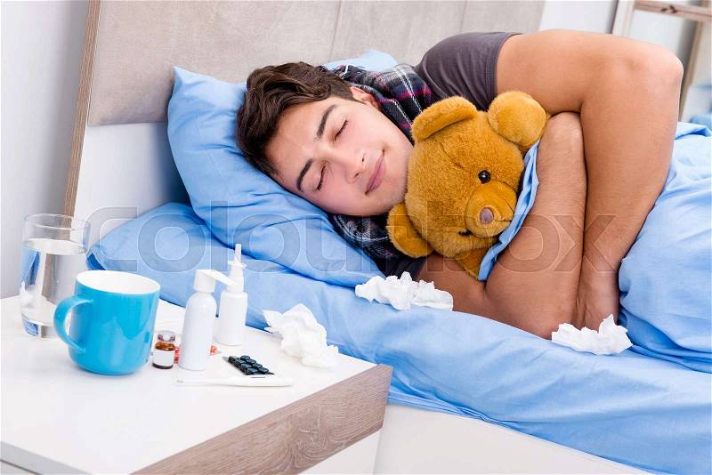 Sick ill man in the bed taking medicines and drugs, stock photo