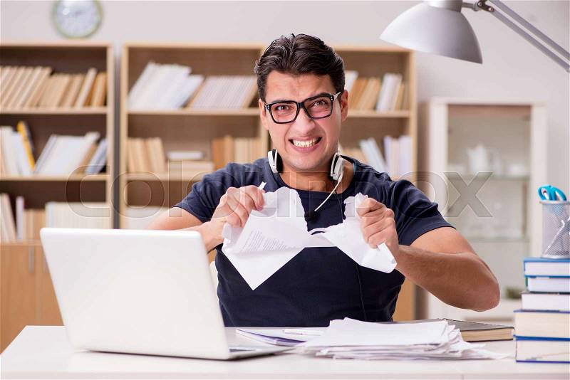 Angry man tearing apart his paperwork due to stress, stock photo