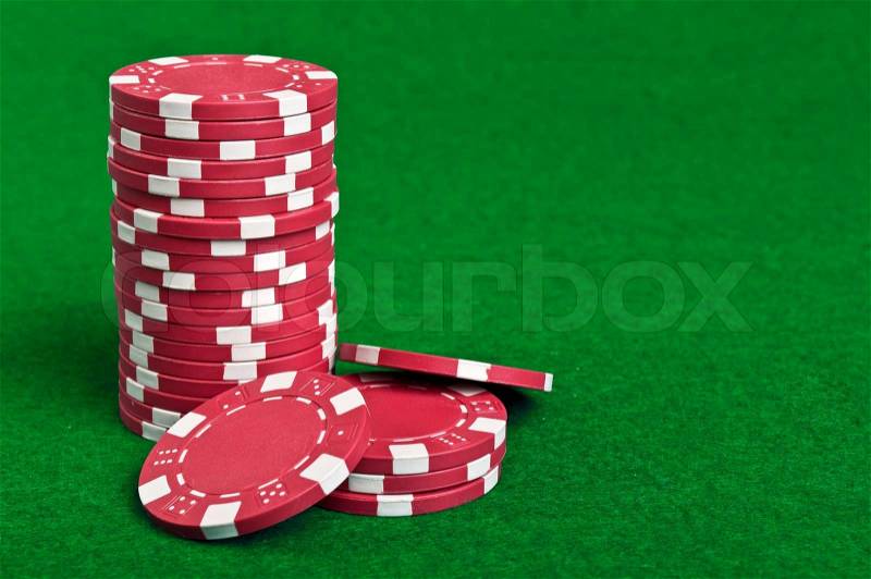 Red poker chips on a green table background, stock photo