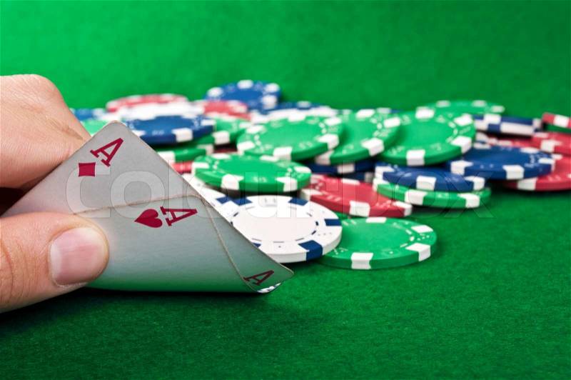 Two aces and poker chips on a green table background, stock photo