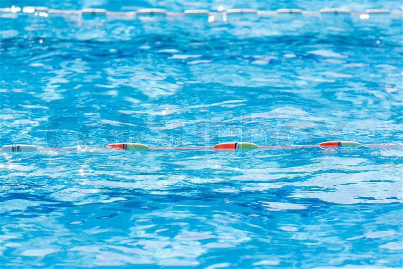 Close up of swimming pool lane divider line on a bright sunny day, selective focus on the color divider, stock photo
