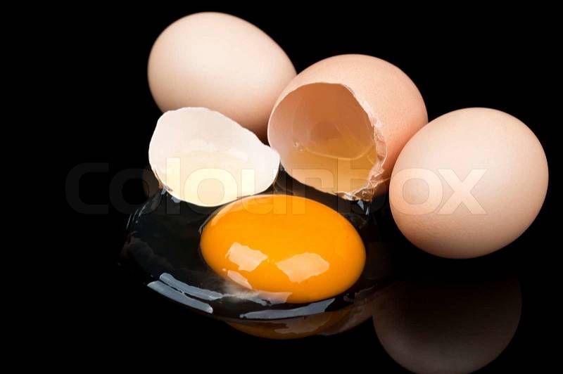 Broken egg isolated on a black background, stock photo