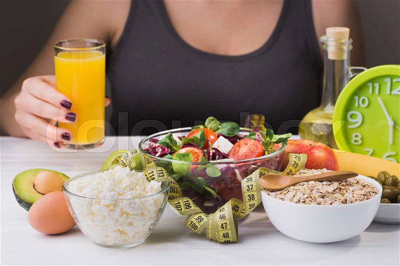 Woman on a diet. healthy and proper food with salad and dairy product on wooden table. Glass of juice in hand, stock photo
