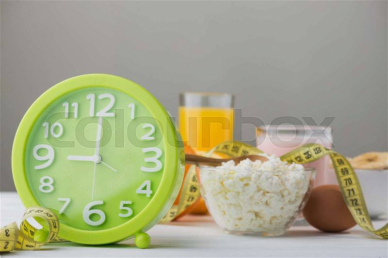 Fresh cheese, orange juice, green watch on a table. Proper and healthy breakfast food, stock photo