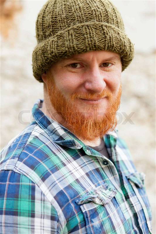 Red haired man with blue plaid shirt and wool hat, stock photo