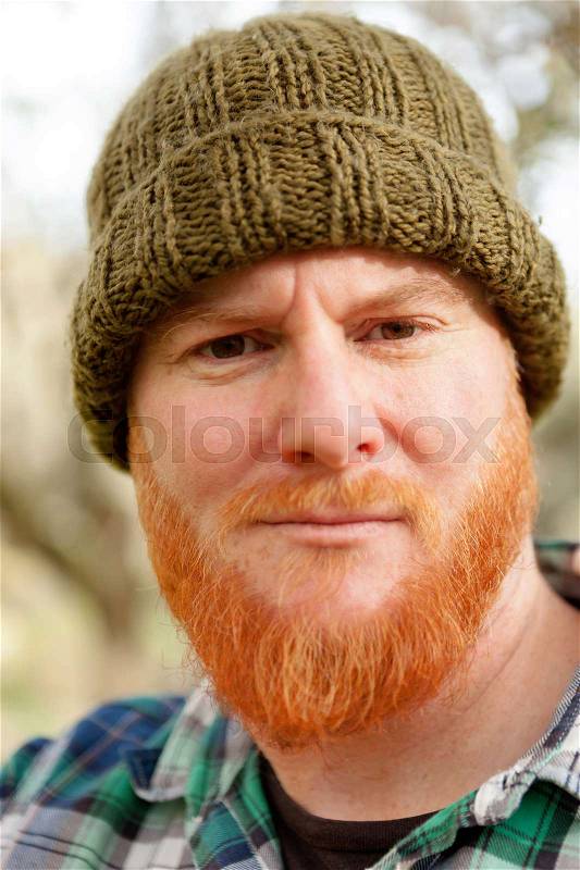 Red haired man with blue plaid shirt and wool hat, stock photo